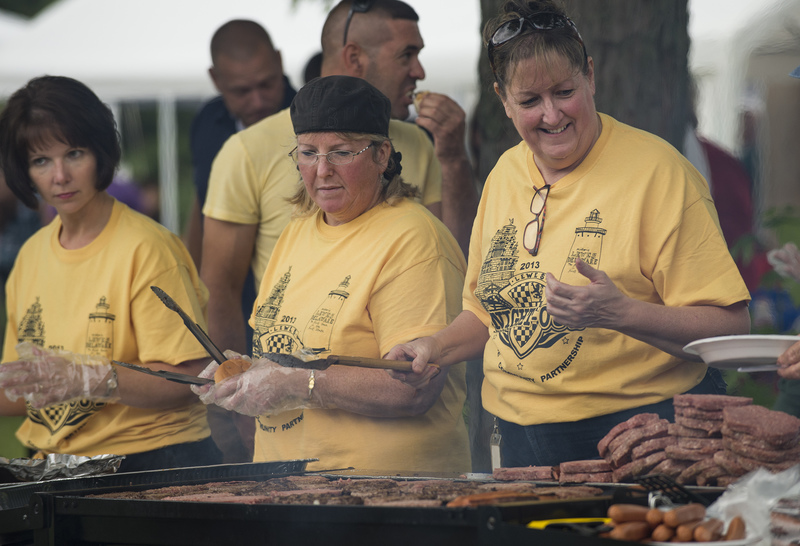 City of Lewes employees (l-r) Ellen Lorraine McCabe, Carol Richardson and Lenora Dillinger keep the grill in action for the free hamburgers and hotdogs. BY DENY HOWETH